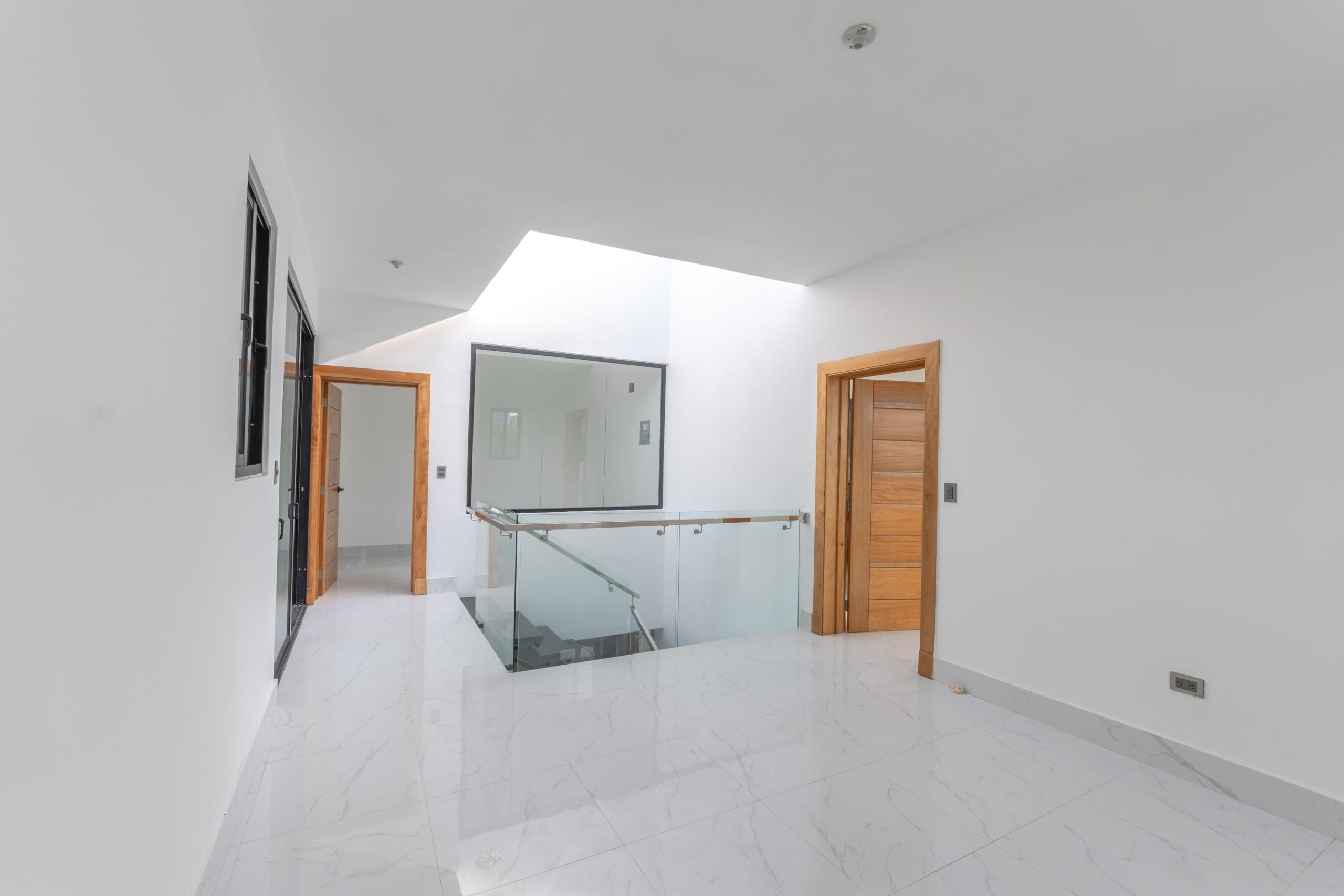 Recibidor con baranda de vidrio y tragaluz en Residencial Payamps I