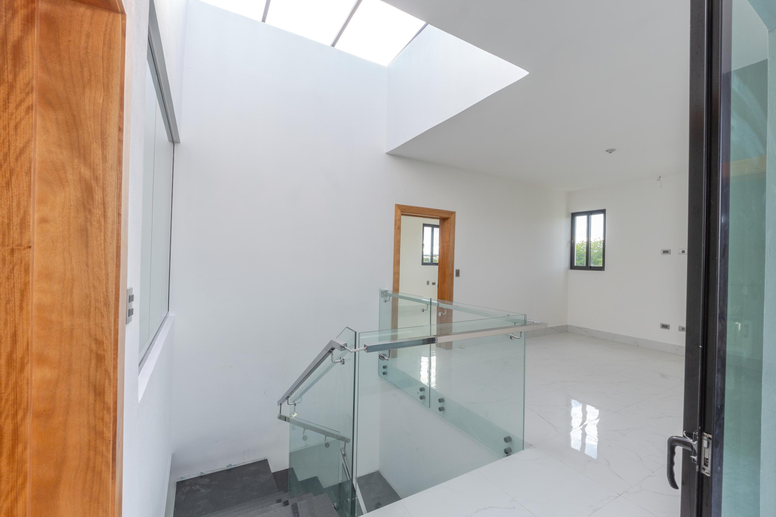 Pasillo con escalera y baranda de vidrio en Residencial Payamps I